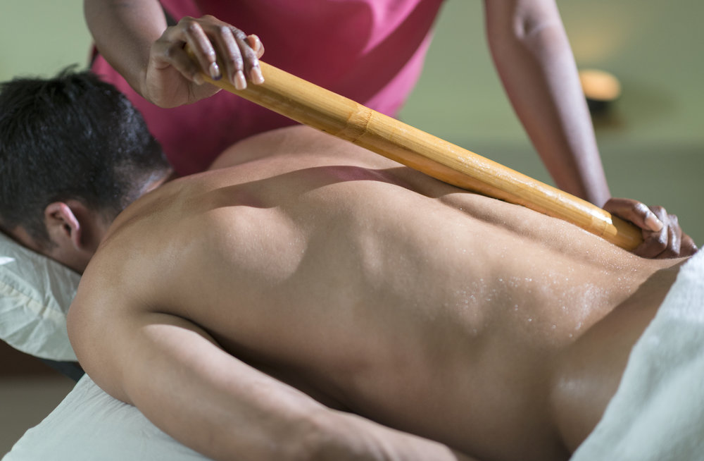 Young man receiving a bamboo massage